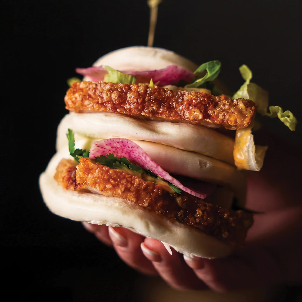 hand holding an asian style sandwich